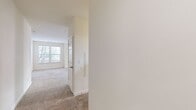 This contemporary apartment at Courts At Huntington Station offers 1070 square feet of well-designed living space. The layout includes two bedrooms, three bathrooms, and an open-concept kitchen and living area. The primary bedroom is a generous 160 square feet, providing ample space for relaxation.

The kitchen showcases a modern aesthetic with a combination of white and dark wood cabinetry, stainless steel appliances, and sleek countertops. A subway tile backsplash adds a touch of classic style. The bathrooms feature large vanities with ample storage, modern fixtures, and a combination of tub and shower options.

Throughout the apartment, neutral-toned carpeting in the bedrooms and living areas creates a warm, inviting atmosphere. Large windows in every room flood the space with natural light and offer views of the surrounding area. A private balcony extends the living space outdoors, perfect for enjoying fresh air or al fresco dining.

The apartment also includes a walk-in closet, providing excellent storage solutions. The overall design emphasizes clean lines, functional spaces, and a bright, airy feel, making it an ideal home for modern living.