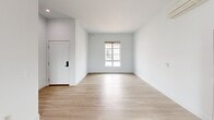 Located at 72 W Santa Clara St, Unit 311 in Ventura, California, this two-bedroom, two-bathroom residence offers a well-designed single-floor layout with a clean, contemporary aesthetic. The open living area greets you upon entry, featuring light wood-tone flooring, crisp white walls, and a window that brings in natural light.

The kitchen is a standout feature, outfitted with rich dark wood cabinetry, light quartz-style countertops, and a full suite of stainless steel appliances including a refrigerator, range, dishwasher, and microwave. A window above the sink provides natural light and ventilation, and the light wood flooring carries through seamlessly from the living area.

Both bedrooms are carpeted in neutral tones and offer a quiet, comfortable retreat. The primary bedroom is a generously sized space featuring a wall-mounted split AC unit and dual closets. The secondary bedroom benefits from a large window with outdoor views of the surrounding neighborhood. Each bathroom is finished with dark wood vanities, white countertops, large mirrors, and wood-look tile flooring, maintaining a consistent modern style throughout. Two hallways connect the spaces efficiently, contributing to the unit's practical and livable flow.