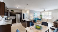 Located at 2010 Jennifer Dr in Davenport, FL, this well-appointed 2-bedroom, 2-bathroom single-story home offers a thoughtfully designed open-concept layout. The combined living, dining, and kitchen area serves as the heart of the home, featuring light wood-style flooring, neutral gray walls, and large windows that invite abundant natural light. A ceiling fan overhead adds both function and style to the living space.

The kitchen is a standout feature, equipped with stainless steel appliances, dark espresso cabinetry, granite countertops, a central island with bar seating, and pendant lighting — ideal for both cooking and entertaining. The adjacent dining area provides comfortable space for a full dining table and chairs.

The primary bedroom is a relaxing retreat with plush carpeting and a ceiling fan, while both bathrooms are finished with granite-topped dark vanities, wood-style tile flooring, and tub-shower combinations. Five closets throughout the home ensure generous storage.

A dedicated laundry room houses a full-size washer and dryer. The hallway connects all rooms efficiently, contributing to a functional and cohesive floor plan. This home combines modern finishes with practical amenities in a comfortable Florida setting.