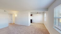 This single-floor unit on E Pembroke Ave in Hampton, Virginia, offers a straightforward, functional layout designed for comfortable everyday living. The open living and dining area features neutral-toned carpeting and clean white walls, with a ceiling fan overhead and a window providing natural light. The space flows directly into the kitchen, which is separated by a partial wall, creating a connected yet defined layout.

The kitchen is well-appointed with rich, dark mahogany-toned cabinetry, light stone-patterned countertops, a stainless steel sink, and a full suite of appliances including a refrigerator, range, and dishwasher. Light wood-look flooring and a recessed ceiling light keep the kitchen bright and easy to maintain.

The bedrooms are carpeted and generously sized, each featuring white walls and windows that allow natural light to filter in. Closets with hanging rods are present in the bedrooms, offering practical storage solutions. The overall color palette throughout the unit is neutral and clean, lending a move-in-ready appearance. The layout, as seen in the 3D overview, shows a well-organized floor plan with clearly defined living, kitchen, and sleeping areas connected by accessible corridors.
