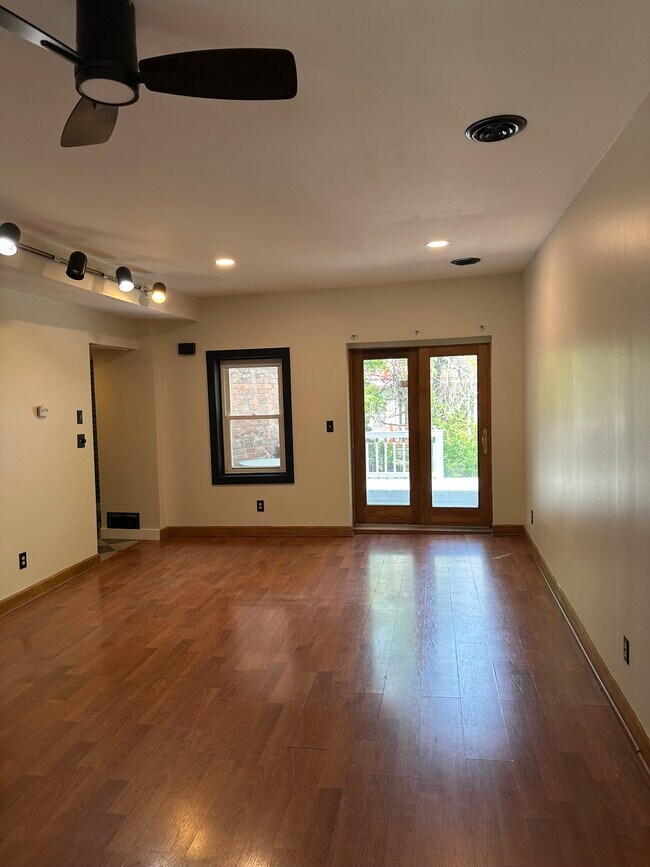 Amplio recibidor con puerta de acceso al patio trasero y ventanas a ambos lados de la habitación. ¡Luminoso y luminoso! - 327 Hudson Ave