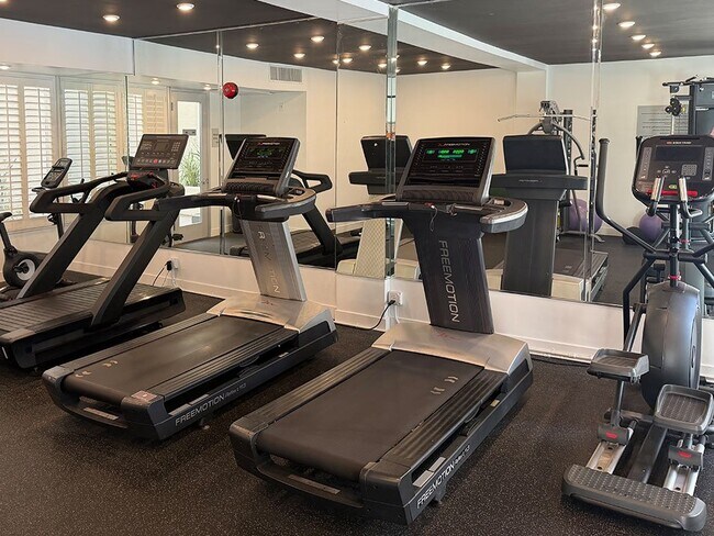 Gimnasio con cintas de correr, pesas libres y bicicletas estáticas. - Clarington Court