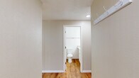 Located in Beaverton, Oregon, this two-bedroom, one-bathroom unit offers a well-designed single-floor layout with a comfortable and functional living environment. The open-concept kitchen and living area serves as the heart of the home, showcasing white shaker-style cabinetry, granite countertops, stainless steel appliances including a refrigerator, range, and microwave, and a peninsula that provides additional prep space and seating. Warm wood-look flooring runs throughout the main living areas, complemented by recessed lighting and pendant fixtures that create a bright, welcoming ambiance. The living room extends to a private outdoor deck through sliding glass doors, bringing in natural light and views of the surrounding greenery. Both bedrooms are carpeted and finished with neutral-toned walls, offering a calm retreat. The primary bedroom is a comfortable size, while the second bedroom also features a sliding closet. The bathroom is cleanly appointed with white cabinetry, a granite-top vanity, and wood-look flooring that ties cohesively to the rest of the unit. Throughout the space, a consistent neutral palette and clean finishes create a move-in ready environment suitable for a variety of lifestyles.