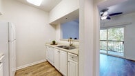 Located at 1501 16th Street in Sacramento, CA, this efficiently designed single-floor unit makes thoughtful use of its compact footprint. The kitchen is appointed with white cabinetry, a double stainless steel sink, light countertops, a dishwasher, and a refrigerator. A pass-through opening connects the kitchen to the dining area, enhancing the sense of openness between the two spaces. The dining and living area features warm wood-style flooring that extends throughout the unit, contributing to a cohesive and welcoming atmosphere. A ceiling fan adds to the comfort of the main living space. Large sliding glass doors lead to a private balcony overlooking lush, mature trees, bringing in abundant natural light and a refreshing outdoor connection. The hallways are clean and well-lit, providing smooth transitions between rooms. The bathroom is neatly finished with wood-style flooring, a vanity with a sink, a large mirror, a combination tub and shower, and a towel bar. Throughout the unit, crisp white walls and consistent flooring create a bright, clean aesthetic. A skylight in the kitchen further enhances the natural light. This unit offers a practical and comfortable layout well-suited for everyday living in the heart of Sacramento.