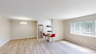 Located at 2200 Milton Rd in University Heights, Ohio, this one-bedroom, one-bathroom residence offers a thoughtfully designed single-floor layout. Light hardwood-style flooring flows throughout the entire unit, creating a cohesive and clean aesthetic. The open-concept living and dining area is bright and airy, with large windows dressed in vertical and horizontal blinds that invite generous natural light and offer outdoor views. A modern pendant light fixture accents the dining area, adding a touch of style to the welcoming entrance. The kitchen is well-appointed with crisp white shaker cabinetry, a subway tile backsplash, stainless steel appliances including a full-size refrigerator, range, and built-in microwave, along with light countertops and a sink. A breakfast bar with bar seating connects the kitchen to the living area, making the space ideal for entertaining. The bedroom is a comfortable, well-proportioned room featuring a large window for natural light and a full-width closet with bifold doors. Additional storage is provided by three closets throughout the unit. A hallway connects the private spaces, and an in-unit laundry area adds everyday convenience. The overall palette of warm neutral tones and textured ceilings gives the home a clean, move-in-ready feel.