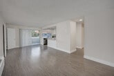 Located at 612 Los Arbolitos Blvd in Oceanside, CA, this single-floor, 3-bedroom, 1-bathroom unit offers a clean and modern living environment. The open-concept living and dining area is bright and airy, featuring light wood-style flooring and a textured ceiling. Sliding glass doors lead to a private balcony, allowing natural light to fill the space. A wall-mounted HVAC unit provides climate control throughout the main living area.

The kitchen is a standout feature, outfitted with crisp white shaker cabinetry, quartz countertops, a large kitchen island, and a full suite of stainless steel appliances including a refrigerator, electric range, over-the-range microwave, and dishwasher. Light wood-style flooring continues seamlessly from the living area into the kitchen.

Three well-proportioned bedrooms are finished with the same light flooring and neutral warm-toned walls. Each bedroom includes a closet with sliding panel doors, and select rooms feature windows with views of the surrounding area. The full bathroom is equipped with a tub-shower combination with chrome fixtures and wood-style flooring. A hallway connects all rooms, ensuring a functional and efficient floor plan throughout.