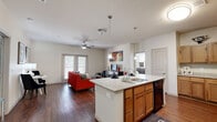 This thoughtfully designed single-story residence offers a comfortable and functional layout across its well-utilized floor plan. The open-concept kitchen and living area serves as the heart of the home, where rich hardwood flooring, a ceiling fan, and French doors leading to the outdoors create a bright and inviting atmosphere. The kitchen is equipped with a granite-topped island with a built-in sink and bar seating, warm wood cabinetry, black appliances, and pendant lighting that adds a modern touch. The living area flows seamlessly from the kitchen, providing an ideal space for both relaxing and entertaining. The primary bedroom features plush carpeting, dual windows that invite natural light, and a ceiling fan for year-round comfort. A dedicated office offers carpeted flooring, a ceiling fan, and a window, making it a versatile space suitable for work or as an additional room. Two full bathrooms serve the residence, one of which includes a tub-shower combination, wood-tone cabinetry, and granite countertops consistent with the home's finishes. Additional spaces include a hallway and a closet for ample storage. The neutral color palette and cohesive design elements throughout create a clean, modern aesthetic.