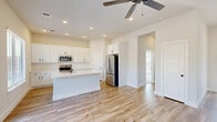 Located in Fate, TX, this single-story home offers a thoughtfully designed layout that maximizes every square foot. The open-concept living, dining, and kitchen area serves as the heart of the home, featuring light wood-look flooring, recessed lighting, and a ceiling fan that enhances airflow and comfort. The kitchen is a standout, showcasing crisp white shaker-style cabinetry with matte black hardware, quartz countertops, a subway tile backsplash, a central island with a built-in sink, and a full suite of stainless steel appliances including a range, over-the-range microwave, and French door refrigerator. A dedicated pantry provides additional storage.

The living room benefits from abundant natural light and offers direct backyard access through sliding glass doors, creating a seamless indoor-outdoor connection. The bedroom is carpeted for comfort, features a ceiling fan, a bright window, and includes two closets for generous storage. The bathroom is cleanly finished with a white vanity, tiled walk-in shower with black-framed glass door, and a window for natural light. Additional spaces include a dedicated laundry area, hallway, and entrance, rounding out a practical and well-appointed home.