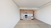 Located at 14500–14522 Titus St in Los Angeles, CA, this single-floor unit offers a clean, modern aesthetic defined by crisp white walls, polished concrete floors, and an open, airy layout. The living area is bathed in natural light through expansive floor-to-ceiling windows, providing views of the surrounding neighborhood and creating a bright, welcoming atmosphere.

The kitchen is thoughtfully designed with light wood cabinetry, white quartz countertops, and a full suite of stainless steel appliances, including a refrigerator, range, microwave, and dishwasher. Recessed lighting and a built-in sink complete the functional, contemporary workspace, which flows seamlessly into the open living area.

The unit includes two well-appointed bathrooms, each featuring white subway tile surrounds in the tub-shower combinations, glass enclosures, floating wood-toned vanities with white countertops, and neutral tile flooring. The bedrooms are finished with clean white walls and offer a versatile, open canvas.

Throughout the unit, exposed ductwork and structural elements add an urban, industrial touch, while the consistent use of light materials and neutral tones contributes to a cohesive and modern living environment. The space strikes a balance between functional design and contemporary style, well-suited to urban Los Angeles living.