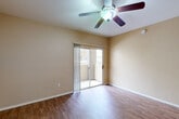 Located at 4045 W Bell Rd in Phoenix, AZ, this one-bedroom, one-bathroom unit offers a practical and well-designed single-floor layout. The combined kitchen and living area serves as the heart of the home, featuring rich dark wood cabinetry, granite countertops, stainless steel appliances, and a peninsula that provides additional prep and dining space. A skylight brightens the kitchen, while wood-style flooring extends throughout the main living areas. The living room is equipped with a ceiling fan and sliding glass doors that open directly onto a private patio, allowing for natural light and outdoor access. The bedroom is a comfortable retreat with plush carpeting, a ceiling fan, and a window that brings in natural light. A dedicated closet provides convenient storage. The bathroom is well-appointed with a dark wood vanity featuring a granite countertop, a full soaking tub with shower, and wood-style flooring that complements the rest of the unit. A hallway connects the main living spaces efficiently. Warm, neutral wall tones are consistent throughout, lending the space a cohesive and inviting ambiance suited for comfortable everyday living in the heart of Phoenix.