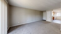 Located at 2725 S Emporia St in Wichita, KS, this apartment offers a practical and well-organized single-floor layout with two bedrooms and one bathroom. The kitchen is equipped with warm honey-toned oak cabinetry, dark countertops, wood-look vinyl flooring, white appliances including a range, dishwasher, and refrigerator, and a pendant light that adds a touch of character. Ample cabinet storage lines both walls, providing generous prep and storage space, while a window allows natural light to brighten the room.

The living area is spacious and open, featuring neutral-toned carpet and a clean, minimalist design that offers flexibility for various furniture arrangements. Both bedrooms are carpeted and finished with neutral walls, with windows that bring in natural light and views of the surrounding area. The primary bedroom includes a built-in closet with louvered bifold doors, providing organized storage, along with convenient access to the bathroom. The full bathroom features a tiled tub-shower combination with built-in shelving, maintaining a clean and functional aesthetic throughout. This apartment presents a straightforward, comfortable living space suited for those seeking practicality in Wichita.
