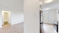 Located at 1050 Castlefield Ave, this thoughtfully designed one-bedroom, one-bathroom unit offers a clean, modern aesthetic with consistent light wood laminate flooring and crisp white walls throughout. The combined kitchen and living area is efficiently laid out, with the galley-style kitchen showcasing white shaker cabinetry, grey quartz countertops, white subway tile backsplash, and stainless steel appliances including a range, over-the-range microwave, and refrigerator. The adjacent living area is open and bright, featuring a large window with a radiator beneath it, allowing natural light to fill the space and offering views of the surrounding neighbourhood. The bedroom is a comfortable, well-proportioned room featuring a sliding double-door closet, a window with natural light, and the same warm wood-tone flooring found throughout the unit. The bathroom is finished with full white subway tile surrounds, a soaking bathtub, chrome fixtures, and a modern vanity with an undermount sink. A private balcony provides outdoor access with open views of Castlefield Avenue. The unit's neutral palette and updated finishes create a clean, move-in-ready environment.