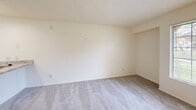 Located at 5200 Coe Ave in Seaside, California, this efficiently designed studio unit offers a well-considered layout that maximizes every square foot. The combined kitchen and living area forms the heart of the unit, where the kitchen is outfitted with white cabinetry featuring brushed nickel hardware, granite-patterned countertops, a gas range, and a full-size refrigerator. Marble-style tile flooring runs through the kitchen, creating a clean and bright foundation. The living area transitions to plush grey carpeting, lending a cozy feel underfoot, and features a textured ceiling and neutral cream-toned walls throughout. A window allows natural light to filter in, offering views of the surrounding greenery. A wall-mounted HVAC unit provides climate control directly within the living space. Built-in open shelving adds a functional design touch near the entryway. The bathroom is well-appointed with a marble-top vanity, white cabinetry, a framed mirror, and wall-mounted shelving for additional storage. Two closets provide ample storage capacity for a unit of this size. The overall aesthetic is clean, light, and functional, making this a practical residence in coastal Seaside.