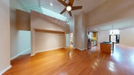 Located on the seventh floor at 911 Locust St in downtown St. Louis, this unit offers a thoughtfully designed open layout with a striking combination of architectural details and modern finishes. The main living area immediately impresses with its dramatically tall ceilings, gleaming hardwood floors, and a ceiling fan with track lighting overhead. A dark granite-surround fireplace anchors one end of the living space, while large windows with blinds allow natural light to fill the room. An open-concept kitchen is equipped with warm maple cabinetry, dark granite countertops with under-cabinet accent lighting, stainless steel appliances including a French door refrigerator and dishwasher, a gas cooktop, and a built-in wine rack. Pendant lights illuminate the central island, which provides additional prep and seating space. The bedrooms feature plush carpeting and tall windows that bring in natural light, creating comfortable, quiet retreats. The bathroom is finished with marble-style tile surrounding the soaking tub and shower, a pedestal sink, chrome fixtures, and glass shelving. Throughout the unit, neutral warm tones and clean architectural lines contribute to a polished, contemporary urban ambiance.