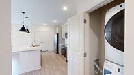 Located in Flat Rock, NC, this thoughtfully designed one-bedroom, one-bathroom residence offers a clean, modern aesthetic across its efficiently laid-out single floor. The open-concept kitchen and living area serves as the heart of the home, where light hardwood-style flooring flows seamlessly throughout. The kitchen is well-appointed with sage-toned shaker cabinets, granite-look countertops, a subway tile backsplash, a central island with a sink, stainless steel appliances including a French door refrigerator, electric range, and built-in microwave, all illuminated by recessed lighting and pendant fixtures overhead. The living area is bright and airy, featuring multiple windows with white blinds that invite natural light, complemented by a ceiling fan for year-round comfort. A private entry door adds convenience. The bedroom offers plush carpeting, dual windows with neighborhood views, a ceiling fan, and access to a dedicated closet with a hanging rod. The bathroom is finished with matching granite-top cabinetry, a subway-tiled tub-shower combination, and warm wood-tone flooring, maintaining the cohesive, contemporary style found throughout the residence.