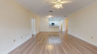Located in Jacksonville, FL (32256), this single-story residence offers a thoughtfully designed layout that balances open communal spaces with comfortable private areas. The main living area is a highlight of the home, featuring light wood-style flooring, crown molding, decorative wainscoting panels, and a ceiling fan with integrated lighting. The space flows naturally into the kitchen, which is defined by a peninsula counter with a clean white finish, ideal for casual dining or meal prep. The kitchen is equipped with stainless steel appliances—including a refrigerator, range, and over-the-range microwave—set against white cabinetry and recessed lighting overhead.

The bedrooms provide a softer atmosphere with neutral-toned carpet and ample wall outlets. The primary bathroom features a wide vanity with a white countertop, a large mirror with overhead lighting, wood-style flooring, and a separate area housing the toilet and soaking tub. A walk-in closet with wire shelving on multiple walls offers generous, organized storage. A secondary bathroom includes a combined tub-shower unit, toilet, and wood-style flooring. Carpeted interior stairs complete the layout, lending a cohesive, comfortable character throughout the home.