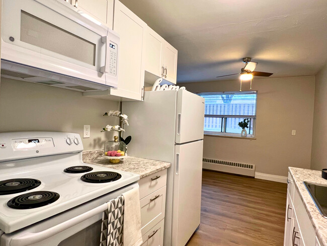 Modern Kitchen with Microwave, Stove & Fridge - Driftwood Apartments