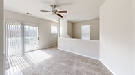 Located at 1402 Bridford Pkwy in Greensboro, NC, this 2-bedroom, 2-bathroom residence offers a well-organized single-floor layout designed for comfortable everyday living. The floor plan includes a hallway connecting the main living areas, two closets, and a dedicated laundry room equipped with washer/dryer hookups and wire shelving for added storage convenience.

Both bedrooms feature soft carpeted flooring, ceiling fans with light fixtures, and windows that allow natural light to filter in with views of the surrounding neighborhood. The primary bedroom provides a generous amount of space and direct access to its own bathroom. The second bedroom is comparably well-sized, also benefiting from a ceiling fan and natural light.

Each of the two full bathrooms features a soaking tub with shower combination, white tile surround, a large vanity mirror, and chrome fixtures. One bathroom is additionally equipped with grab bars, enhancing accessibility. The neutral, warm-toned walls throughout the residence create a clean and cohesive aesthetic. The living area opens to an outdoor balcony, providing a pleasant outdoor extension of the interior. Overall, the space presents a practical and comfortable layout suited for a variety of lifestyles.