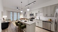 This thoughtfully designed one-bedroom, one-bathroom unit offers an efficient and modern single-floor layout. The open-concept kitchen and living area serves as the heart of the space, featuring wood-look plank flooring, soaring ceilings, and large floor-to-ceiling windows that flood the interior with natural light. The kitchen is well-appointed with gray shaker-style cabinetry, a white subway tile backsplash, stainless steel appliances including a full-size refrigerator and dishwasher, quartz countertops, and a central island with built-in storage and bar seating for two. Pendant lighting and a track lighting system add both ambiance and function. A stacked in-unit washer and dryer is conveniently tucked near the kitchen entry. The living area offers direct access to an outdoor space through glass doors. The bedroom provides a comfortable retreat with its own large window, wood-look flooring, and access to a dedicated walk-in closet. The bathroom features a tub-shower combination with tile surround, a vanity with stone countertop, and matte black fixtures that complement the unit's contemporary aesthetic throughout.