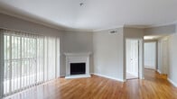 Located at 2742 Jeanetta St in Houston, TX, this single-floor residence offers a well-designed layout with cohesive finishes throughout. The living room serves as the heart of the home, showcasing warm hardwood flooring, crown molding, and a classic white-mantled corner fireplace. Vertical blinds frame sliding glass doors that invite natural light and provide access to an outdoor area with greenery views, creating a bright and welcoming atmosphere.

The kitchen is thoughtfully designed in a galley configuration, featuring rich dark cabinetry, light granite countertops, stainless steel appliances including a range, microwave, and refrigerator, and a convenient pass-through breakfast bar that connects seamlessly to the adjacent living and dining areas. Hardwood flooring continues throughout the main living spaces.

The bedrooms are carpeted for comfort and each include ceiling fans and sliding glass doors that open to private outdoor access with lush exterior views. One bedroom features a walk-in closet, adding practical storage.

The bathroom includes a dual-sink vanity with dark cabinetry and a large framed mirror. A dedicated laundry area with an in-unit washer connection is conveniently accessible nearby. Throughout the home, neutral gray tones, white trim, and consistent finishes create a clean, move-in-ready aesthetic.