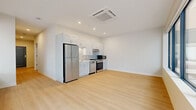 Located at 29 Seventh St W in Cincinnati, OH, this modern 2-bedroom, 2-bathroom residence offers a thoughtfully designed single-floor layout with a clean, contemporary aesthetic throughout. Light wood flooring runs continuously across the space, complementing the crisp white walls and creating a bright, cohesive atmosphere.

The open-concept living, dining, and kitchen area forms the heart of the residence. The kitchen is outfitted with white shaker cabinetry, stainless steel appliances including a refrigerator, gas range, dishwasher, and microwave, and recessed lighting above. A ceiling-mounted HVAC unit ensures year-round comfort.

A wide hallway connects the main living area to the two bedrooms, each finished with the same warm wood flooring and neutral tones. The primary bedroom is generously sized and benefits from expansive floor-to-ceiling corner windows that overlook an outdoor terrace, flooding the room with natural light. The secondary bedroom includes dedicated closet space with built-in shelving. Three closets in total provide ample storage throughout.

Both bathrooms are finished in a clean, modern style, featuring light tile flooring, a tub-shower combination with white tile surround, and vanities with illuminated mirrors. The overall ambiance is fresh, minimalist, and move-in ready.
