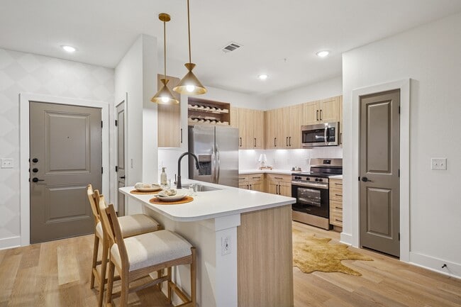 Kitchen with Quartz Countertop and Stainless Steel Appliances - The Sylvan at Painted Tree