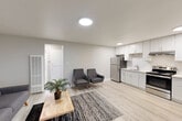 Located at 319 E Tabor Ave in Fairfield, CA, this efficiently designed one-bedroom, one-bathroom unit offers a clean, modern aesthetic across a single floor. Light-toned laminate flooring flows throughout, complementing the neutral gray walls and bright flush-mount ceiling lights that keep the space feeling open and well-lit.

The combined living, dining, and kitchen area forms the heart of the unit. The living area provides comfortable space for seating and a dining setup, with a window allowing natural light to filter in. The kitchen is thoughtfully appointed with crisp white shaker-style cabinetry, light quartz countertops, a subway tile backsplash, stainless steel refrigerator, and a stainless steel range with an overhead vent hood — offering a modern and functional cooking environment.

The bedroom is a calm, private retreat with a window fitted with blinds, ample wall space, and continued light flooring, along with access to closet storage. A hallway connects the main living areas to the bedroom and bathroom, which includes a full soaking tub and shower combination with a window for natural ventilation. Two closets provide practical storage solutions throughout the unit. The overall design is clean, contemporary, and move-in ready.