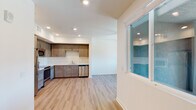 Located at 2640 Wagon Wheel Rd in Oxnard, California, this contemporary single-floor unit is thoughtfully designed with modern finishes and a clean, open aesthetic. The layout flows naturally from the main living area into the kitchen, creating a cohesive and functional space throughout.

The kitchen is a standout feature, offering warm-toned shaker-style cabinetry, bright white countertops, and a full suite of stainless steel appliances including a refrigerator, electric range, microwave, and dishwasher. Recessed lighting illuminates the space efficiently, complementing the light hardwood-style flooring that runs throughout the main living areas.

The living space is bright and airy, enhanced by a full-light entry door and sliding windows that invite natural light and outdoor views of the surrounding Oxnard landscape. A ceiling fan adds comfort to the living area. A dedicated bedroom features plush carpeting and a large sliding window framing views of the neighborhood and palm-lined surroundings.

The bathroom is clean and well-appointed, featuring a tiled tub-shower combination, wood-toned vanity cabinetry, a white countertop, and matching light hardwood-style flooring. Throughout the unit, the design emphasizes a neutral, modern palette that creates a bright and welcoming atmosphere.