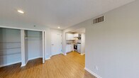 Located at 300 W Airport Blvd in Sanford, Florida, this single-floor, 2-bedroom, 2-bathroom residence offers a functional and well-appointed layout designed for comfortable living. The living room serves as the heart of the home, featuring wood-look flooring, neutral gray walls, a textured ceiling, and a set of French doors that invite natural light and provide outdoor views. The kitchen is efficiently designed with white shaker-style cabinetry, granite-look countertops, and stainless steel appliances including a refrigerator, microwave, and range. It connects seamlessly to a hallway that leads to both bedrooms and bathrooms. The primary bedroom offers a generous footprint with wood-look flooring, a window for natural light, and access to a dedicated closet fitted with wire shelving on both sides for ample storage. The second bedroom mirrors the clean, neutral aesthetic with its own window and hardwood-style flooring. Both bathrooms are fitted with a tub-shower combo and clean white fixtures. Throughout the residence, consistent flooring, crisp white trim, and a soft gray color palette create a cohesive and move-in-ready atmosphere.
