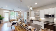 Located at 11101 W Airport Blvd in Stafford, Texas, this thoughtfully designed single-floor residence offers a seamless blend of modern style and everyday functionality. The open-concept layout connects the kitchen, dining, and living areas, creating a bright and welcoming atmosphere ideal for both relaxing and entertaining. The kitchen is a standout feature, showcasing crisp white shaker cabinetry, dark quartz countertops, a textured subway tile backsplash, open display shelving, and a full suite of stainless steel appliances including a French door refrigerator, electric range, built-in microwave, and dishwasher. Warm hardwood-style flooring flows throughout the main living areas. The living room is bathed in natural light from large windows and a glass door that opens to a private balcony, and is finished with a ceiling fan overhead. The primary bedroom offers plush carpeting, a ceiling fan, and a well-appointed en-suite bathroom featuring dark quartz countertops, white cabinetry, a large vanity mirror, and direct access to a spacious walk-in closet. A second bedroom with a soothing blue accent wall and natural light adds versatility. A dedicated in-unit laundry area with full-size washer and dryer completes this well-appointed home.
