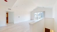 Located at 3223 W 111th St in Naperville, IL, this thoughtfully designed 2-bedroom, 2-bathroom residence offers a bright, contemporary living experience across a single floor. The open living area is anchored by striking vaulted ceilings and light-toned hardwood flooring that flows throughout the space, creating an airy, expansive feel. Large sliding glass doors lead to a private balcony, inviting natural light and outdoor views into the main living area.

The kitchen is a standout feature, showcasing white shaker cabinetry with matte black hardware, a dramatic marble-veined quartz backsplash, and matching quartz countertops on both the perimeter and the two-tone island with a built-in sink. Stainless steel appliances, a gas range, and pendant lighting complete this well-appointed culinary space.

Both bathrooms are finished with clean, modern details — one featuring a full soaking tub with subway tile surround and oil-rubbed bronze fixtures, and another with a white shaker vanity and sleek hardware. The primary bedroom is generously sized and is complemented by a spacious walk-in closet with built-in shelving and hanging systems. A second closet provides additional storage. The overall palette of crisp whites and warm neutrals gives the entire residence a fresh, move-in-ready appeal.
