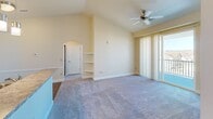 Located at 7761 Bear Run Pt in Colorado Springs, CO, this one-bedroom, one-bathroom home offers a well-designed single-floor layout with a variety of functional spaces. The open-concept living and dining area is highlighted by soaring vaulted ceilings and a ceiling fan, creating an airy, spacious feel. Soft carpeting runs throughout the living area, while built-in wall shelves add a practical architectural detail. Sliding glass doors lead to a private balcony, filling the space with natural light. The kitchen is a standout feature, showcasing rich dark cabinetry, granite-style countertops, a large peninsula island with a sink, black appliances including a range and refrigerator, and pendant lighting overhead — all set on hardwood-style flooring. The bedroom is a comfortable retreat with carpet flooring, a ceiling fan, and a window offering views of the surrounding neighborhood. Two closets provide ample storage. The bathroom includes a full tub/shower combo with chrome fixtures, a vanity with dark cabinetry, and hardwood-style flooring. Additional conveniences include a dedicated laundry area, an entrance hallway, and easy access to all rooms via a central hallway.