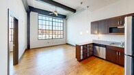 This contemporary 780 sq ft apartment in Winston-Salem boasts 2 bedrooms and 2 bathrooms. The space combines industrial and modern aesthetics with exposed ductwork, large windows, and hardwood floors throughout. The kitchen features stainless steel appliances and granite countertops. Bathrooms are equipped with modern fixtures, including a shower/tub combo. The primary bedroom, at 170 sq ft, offers ample space. A convenient in-unit laundry area with stacked washer and dryer adds functionality. High ceilings and expansive windows flood the rooms with natural light, offering scenic city views and creating an open, airy atmosphere.