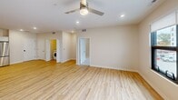 Located at 900 3rd St SE in Cedar Rapids, Iowa, this thoughtfully designed 1-bedroom, 2-bathroom residence offers generous single-floor living with a clean, contemporary aesthetic throughout. The open-concept kitchen and living area serves as the heart of the home, featuring light hardwood-style flooring, recessed lighting, and a ceiling fan for year-round comfort. The kitchen is well-appointed with crisp white shaker cabinetry, stainless steel appliances including a range, over-the-range microwave, refrigerator, and dishwasher, complemented by a walk-in pantry for ample storage. Large windows in the living area invite natural light and provide views of the surrounding neighborhood. The spacious primary bedroom is finished with plush carpeting, a ceiling fan, and a sizable window that further enhances the bright atmosphere. Two full bathrooms offer practical convenience, each finished with white vanity cabinetry, solid countertops, and hardwood-style flooring; one bathroom features a tub/shower combination. An in-unit washer is also present, adding everyday functionality. Neutral warm-toned walls throughout create a cohesive and inviting ambiance, making this a versatile and comfortable living space.