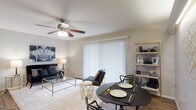 Located at 8000 Midcrown Dr in San Antonio, Texas, this single-floor residence offers a well-designed layout that seamlessly blends comfort and modern style. The open-concept living and dining area serves as the heart of the unit, featuring warm wood-look flooring, a ceiling fan, and a large sliding glass door dressed with vertical blinds that floods the space with natural light and provides direct access to a private patio. The living area is anchored by a plush area rug and connects effortlessly to the dining space, which is served by a pass-through window from the kitchen. The galley-style kitchen is outfitted with dark cabinetry, light countertops, a tile backsplash, and black appliances, offering ample storage and counter space in an efficient layout. The bedroom is a comfortable retreat with wood-look flooring, a ceiling fan, and a walk-in closet providing generous storage. The bathroom features a tub-shower combination. Throughout the unit, neutral gray walls, consistent flooring, and thoughtful design details create a cohesive and contemporary ambiance, making this San Antonio residence a functional and attractive living space.