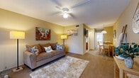 This 2-bedroom, 1-bathroom residence is thoughtfully arranged on a single floor, making efficient use of its compact footprint. The living room serves as the welcoming heart of the home, featuring warm beige walls, soft carpeting, a ceiling fan with integrated lighting, and a textured ceiling. Large sliding glass doors with vertical blinds flood the space with natural light while providing direct access to an outdoor area. The living room flows seamlessly into the adjacent dining area, which offers a cozy setting beneath a pendant light. The galley-style kitchen is efficiently designed with wood-toned cabinetry, a gas range, a full-size refrigerator, a stainless steel sink, and a decorative tile backsplash, all set over tile flooring. The primary bedroom is a comfortable retreat featuring built-in closets with bi-fold doors, carpeted flooring, a wall-mounted HVAC unit, and a large window dressed with vertical blinds that brings in ample natural light. The second bedroom mirrors a similar layout with carpeted floors and closet storage. The shared bathroom includes a single-sink vanity with wood cabinetry, tile flooring, and a shower-tub combination. Throughout the residence, a consistent warm color palette and carpet flooring create a cohesive and inviting atmosphere.
