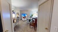 Located at 11103 C St S in Tacoma, Washington, this single-floor residence offers a well-organized and functional layout across several distinct living areas. The living room serves as the heart of the home, featuring plush carpeting, abundant natural light from multiple windows, and access to an outdoor area through a sliding glass door. The open, airy feel is complemented by neutral-toned walls that lend a clean, welcoming atmosphere throughout.

The kitchen is thoughtfully designed with light wood cabinetry, white countertops, and a peninsula with a built-in sink that adds both workspace and a casual seating option. Black appliances, including an electric range with overhead microwave and a stainless steel refrigerator, are paired with wood-look flooring and recessed and track lighting overhead, creating a practical yet stylish culinary space.

The bedroom is a calm retreat featuring carpeted floors, a well-sized closet, and a softly lit ambiance. A full bathroom adjacent to the sleeping area includes a tub-shower combination, a vanity with light countertops, and wood-look flooring, offering clean and efficient functionality.

An additional room provides flexible use as a home office or den, complete with carpeted floors, a window with natural light, and ample space for a desk and seating area. The overall layout is efficient and cohesive, making the most of the available space throughout.