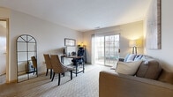 Located at 6108 Chestnut Ridge Dr in Columbus, OH, this efficiently designed single-floor unit offers a well-organized layout across three distinct spaces. The combined kitchen and living area serves as the heart of the unit, where the living space features soft carpet flooring, neutral walls, and a sliding glass door that opens to a private outdoor patio, filling the room with natural light and providing a pleasant outdoor view. The kitchen is equipped with light wood cabinetry, dark countertops, a full suite of white appliances including a range and refrigerator, wood-look flooring, and a peninsula that provides additional prep space and separation from the living area. Track lighting overhead adds a functional and modern touch. The dedicated office is a standout feature, offering carpeted flooring, a natural light-filled window, and ample room for a full desk setup and seating — ideal for professional or personal use. The bathroom is clean and straightforward, featuring wood-look tile flooring, a full bathtub with shower, a vanity with storage, and classic white fixtures. Throughout the unit, the neutral color palette and consistent finishes create a cohesive and calm ambiance well-suited for both living and working.