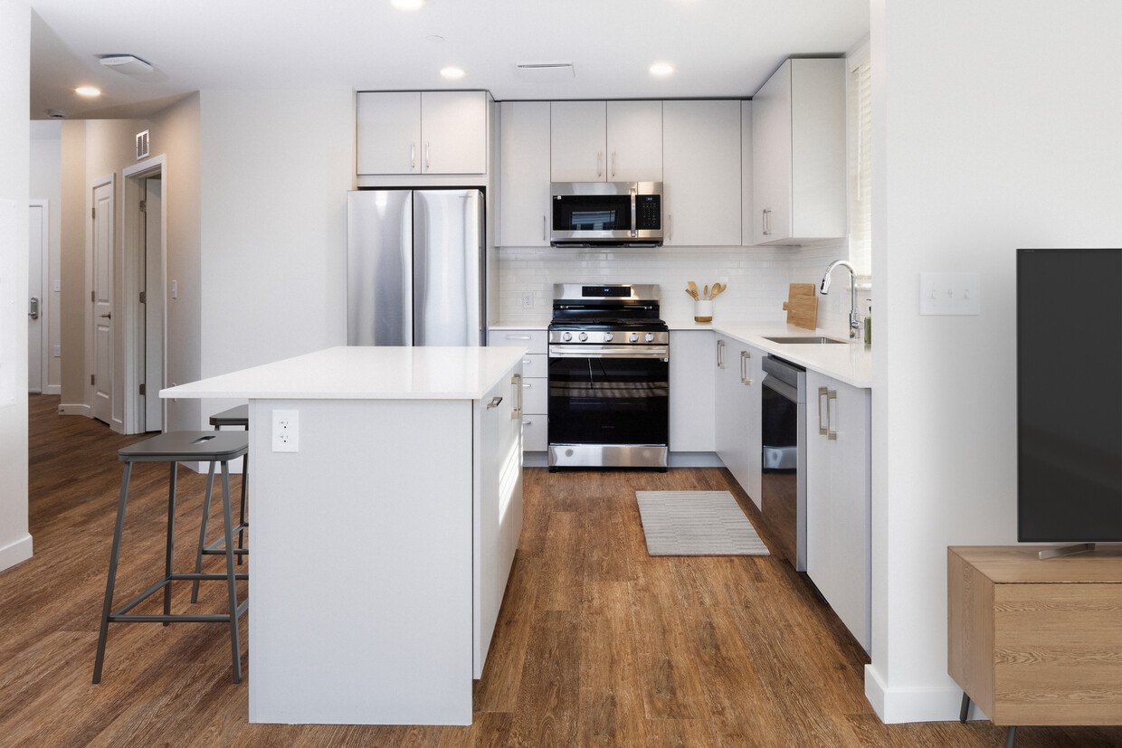 Finish Scheme II kitchen with stainless steel appliances, white quartz countertop, light grey cabinetry, and hard surface flooring (representative photo) - Avalon Governors Park