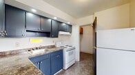 Located at 1250 Kelburn Rd in Columbus, Ohio, this two-story home offers a practical and well-organized layout across both levels. The kitchen is a standout space, outfitted with bold navy blue cabinetry — both upper and lower — complemented by granite-look countertops, recessed lighting, a white electric range, a double-basin sink, and a refrigerator. Tile flooring and a window add brightness and functionality to the space. A dedicated laundry area with overhead cabinetry and utility hookups provides added convenience. The living area on the main floor features warm carpeting, a window for natural light, and a staircase with a dark metal railing leading to the upper level. Upstairs, the bedrooms are generously proportioned, each finished with soft carpeting and ceiling fans. Multiple windows in the bedrooms allow ample natural light to filter in, offering views of the surrounding neighborhood. The full bathroom includes a tub-shower combination, a white vanity with under-cabinet storage, a medicine cabinet with mirror, and tile flooring. Throughout the home, clean white walls and neutral finishes create a bright, move-in-ready atmosphere suited for comfortable everyday living.