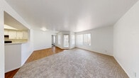Located at 3651 N Rancho Dr in Las Vegas, NV, this two-bedroom, one-bathroom single-floor unit offers a practical and comfortable layout. The open living and dining area features a combination of warm wood-look flooring and plush carpet, bathed in natural light from a large front-facing window and a glass entry door. The clean white walls and textured ceilings throughout lend a bright, neutral ambiance to the space.

The kitchen is efficiently designed with white cabinetry, light countertops, wood-look flooring, and black appliances including a refrigerator, electric range with overhead ventilation, and dishwasher — providing ample functionality for everyday cooking.

Both bedrooms are carpeted and feature vertical blind-covered windows that allow natural light to filter in. The primary bedroom is generously sized and includes direct access to the full bathroom, which is finished with a white vanity, wood-look flooring, and a tiled tub and shower combination.

Additional practical spaces include two closets and a utility room, offering meaningful storage and household functionality. The overall design is clean and consistent, with a neutral palette that makes the space feel open and move-in ready.
