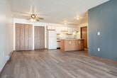 Located at 2945 Red Fox Run in Portage, Wisconsin, this well-appointed two-bedroom, one-bathroom home offers a comfortable and functional single-floor layout. Light wood-style flooring runs throughout, complementing neutral wall tones and creating a bright, cohesive atmosphere. The open-concept kitchen and living area serves as the heart of the home, featuring warm wood cabinetry, a white countertop peninsula ideal for casual dining or meal prep, a tile backsplash, and white appliances including a refrigerator and range. The living area is generously sized, with a sliding glass door that fills the space with natural light and a wall-mounted AC unit for year-round comfort. A distinctive slate-blue accent wall adds a modern touch to the main living space. Each bedroom offers ceiling fans, ample natural light through large windows with vertical blinds, and easy access to the hallway. The bathroom is clean and functional, featuring a tub/shower combination with grab bars and recessed lighting. Three closets provide excellent storage throughout. In-unit laundry adds everyday convenience. Baseboard heating is present throughout, and textured ceilings add a classic finishing detail to this move-in-ready home.