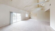 Located at 10 Sunny Meadow Ct in Baltimore, MD, this single-floor, 2-bedroom, 2-bathroom home offers a thoughtfully designed layout with a range of distinctive architectural features. The combined living and dining area is the centerpiece of the home, boasting soaring vaulted ceilings with exposed beam detailing, a cozy fireplace, and plush carpeting throughout. Sliding glass doors lead directly to an outdoor deck, allowing an abundance of natural light to fill the space. The kitchen features white cabinetry, granite-toned countertops, hardwood flooring, and includes white appliances — refrigerator, range, microwave, and dishwasher — alongside a stainless sink. Both bedrooms are generously sized and carpeted, each equipped with double closets for ample storage. The primary bedroom is particularly spacious, offering two side-by-side reach-in closets. The second bedroom benefits from dual windows with views of surrounding greenery. The two full bathrooms each feature a tub-shower combo with white tile surrounds. One bathroom showcases marble-style tile flooring. Additional highlights include multiple hallways, four closets throughout, and a dedicated laundry area, rounding out this well-equipped and comfortable home.