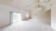 Located at 10 Sunny Meadow Ct in Baltimore, MD, this single-floor, 2-bedroom, 2-bathroom home offers a thoughtfully designed layout with a range of distinctive architectural features. The combined living and dining area is the centerpiece of the home, boasting soaring vaulted ceilings with exposed beam detailing, a cozy fireplace, and plush carpeting throughout. Sliding glass doors lead directly to an outdoor deck, allowing an abundance of natural light to fill the space. The kitchen features white cabinetry, granite-toned countertops, hardwood flooring, and includes white appliances — refrigerator, range, microwave, and dishwasher — alongside a stainless sink. Both bedrooms are generously sized and carpeted, each equipped with double closets for ample storage. The primary bedroom is particularly spacious, offering two side-by-side reach-in closets. The second bedroom benefits from dual windows with views of surrounding greenery. The two full bathrooms each feature a tub-shower combo with white tile surrounds. One bathroom showcases marble-style tile flooring. Additional highlights include multiple hallways, four closets throughout, and a dedicated laundry area, rounding out this well-equipped and comfortable home.
