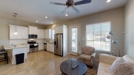 This single-story, 2-bedroom, 2-bathroom residence offers a thoughtfully designed open-concept layout that efficiently connects the main living areas. Polished concrete floors flow continuously throughout the home, providing a cohesive and low-maintenance foundation that complements the neutral, light-toned walls.

The kitchen is outfitted with white shaker-style cabinetry, granite countertops, and a full suite of stainless steel appliances, including a French door refrigerator, gas range, dishwasher, and microwave. A peninsula with additional counter space connects the kitchen to the dining area, which is anchored by an elegant chandelier and receives natural light from nearby windows.

The living room is comfortable and well-lit, featuring recessed lighting, a ceiling fan, and windows that invite natural light. Both bedrooms maintain the polished concrete flooring, soft wall tones, and ceiling fans, creating a calm, restful atmosphere.

The bathrooms are clean and functional, with the full bath offering a tub-shower combination and white cabinetry for storage. A dedicated laundry area with overhead cabinetry and washer/dryer connections adds practical convenience. Overall, the home presents a clean, modern aesthetic throughout.