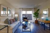 Located at 2400 Yorktown St in Houston's Galleria area, this single-floor residence offers a thoughtfully designed layout with a warm, neutral palette throughout. The living room features hardwood-style flooring, track lighting, and a sliding glass door that opens to a private patio, filling the space with natural light and providing seamless indoor-outdoor living. A dedicated dining area sits adjacent to the living room, accented by track lighting and hardwood-style flooring, ideal for entertaining. The kitchen is outfitted with white cabinetry, granite-style countertops, tile backsplash, and stainless steel appliances including a range and over-the-range microwave. The bedrooms are carpeted and equipped with ceiling fans, ample closet space, and windows with natural light. The primary bedroom is generously proportioned with room for a sitting area. The bathrooms feature tile flooring, a tub-shower combination, and vanity countertops with ample storage. A hallway bath includes a separate vanity area with hardwood-style flooring. The overall ambiance is light, airy, and welcoming, with a cohesive coastal-inspired design aesthetic evident throughout.