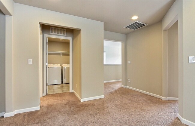Upstairs loft looking into laundry room with bedrooms #2 and #3 to the right, master bedroom to the left. - 8840 Jayden Dr NE