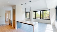 Located at 41 Ridge Square NW in Washington, DC, this thoughtfully designed 3-bedroom, 2-bathroom residence offers a clean, contemporary aesthetic across a well-organized single-floor layout. Light wood flooring and crisp white walls flow throughout the space, creating a bright and cohesive ambiance.

The open-plan kitchen and living area serves as the heart of the home. The kitchen is outfitted with sleek two-tone cabinetry in warm wood and matte gray, a marble-look countertop and backsplash, stainless steel appliances including double wall ovens, a black fixtures sink, and a generous waterfall island topped with a stone surface and illuminated by three modern pendant lights. Large black-framed windows frame lush outdoor greenery, filling the space with natural light.

The three bedrooms are generously proportioned, each featuring the same light hardwood flooring and expansive black-framed windows that invite abundant sunlight and offer pleasant views of the surrounding neighborhood. The primary bedroom benefits from corner windows on two walls.

Six closets—including well-appointed walk-in closets with built-in wire shelving systems—provide exceptional storage throughout. The bathrooms are finished with large-format neutral tile, soaking tubs, and brushed nickel fixtures. Connecting hallways are clean and uncluttered, with recessed lighting reinforcing the home's modern character.