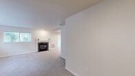 Located at 725 N Center Pkwy in Kennewick, WA, this single-floor, 2-bedroom, 2-bathroom unit offers a well-organized layout with a comfortable, neutral aesthetic throughout. The living room is a welcoming space anchored by a brick fireplace and lined with multiple windows that invite generous natural light and views of the surrounding greenery. Soft carpeting extends through the living areas and bedrooms, contributing to a warm ambiance.

The kitchen is efficiently designed in a galley configuration, featuring crisp white cabinetry, light quartz-style countertops, tile flooring, and a full suite of stainless steel appliances including a refrigerator, electric range, and microwave. An open shelving pantry area adjacent to the kitchen provides convenient additional storage.

The primary bedroom offers a comfortable footprint with a sliding closet and direct access to a hallway leading to its bathroom. The second bedroom is bright and airy, benefiting from a window with outdoor views. Both bathrooms are finished with tile flooring and glass-enclosed tub/shower combinations — one featuring a pedestal sink and the other a traditional vanity with mirror. Hallways connect the rooms in a logical flow, making this a practical and livable unit.