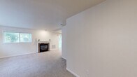 Located at 725 N Center Pkwy in Kennewick, WA, this single-floor, 2-bedroom, 2-bathroom unit offers a well-organized layout with a comfortable, neutral aesthetic throughout. The living room is a welcoming space anchored by a brick fireplace and lined with multiple windows that invite generous natural light and views of the surrounding greenery. Soft carpeting extends through the living areas and bedrooms, contributing to a warm ambiance.

The kitchen is efficiently designed in a galley configuration, featuring crisp white cabinetry, light quartz-style countertops, tile flooring, and a full suite of stainless steel appliances including a refrigerator, electric range, and microwave. An open shelving pantry area adjacent to the kitchen provides convenient additional storage.

The primary bedroom offers a comfortable footprint with a sliding closet and direct access to a hallway leading to its bathroom. The second bedroom is bright and airy, benefiting from a window with outdoor views. Both bathrooms are finished with tile flooring and glass-enclosed tub/shower combinations — one featuring a pedestal sink and the other a traditional vanity with mirror. Hallways connect the rooms in a logical flow, making this a practical and livable unit.